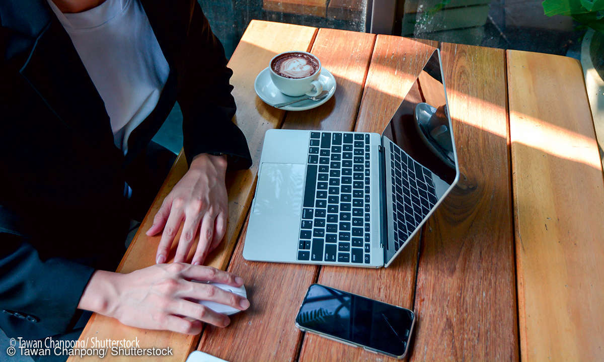 Laptopnutzer mit Smartphone