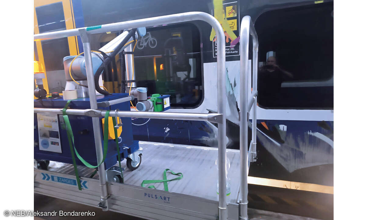 Der Laser eines mobilen Roboters  brennt das Transparenz schaffende  Muster in eine Scheibe.